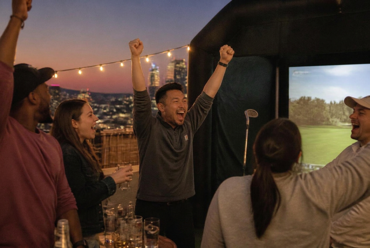 Group celebrating with arms raised on a rooftop at dusk beside the enclosure